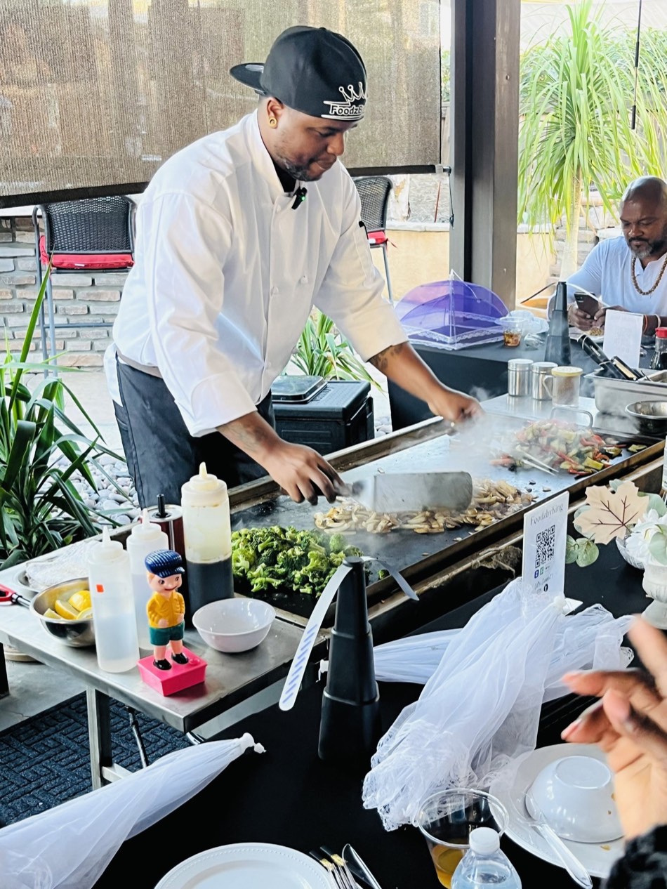 Chef Mike King cooking shrimp and vegetables at the hibachi grill at a client's event