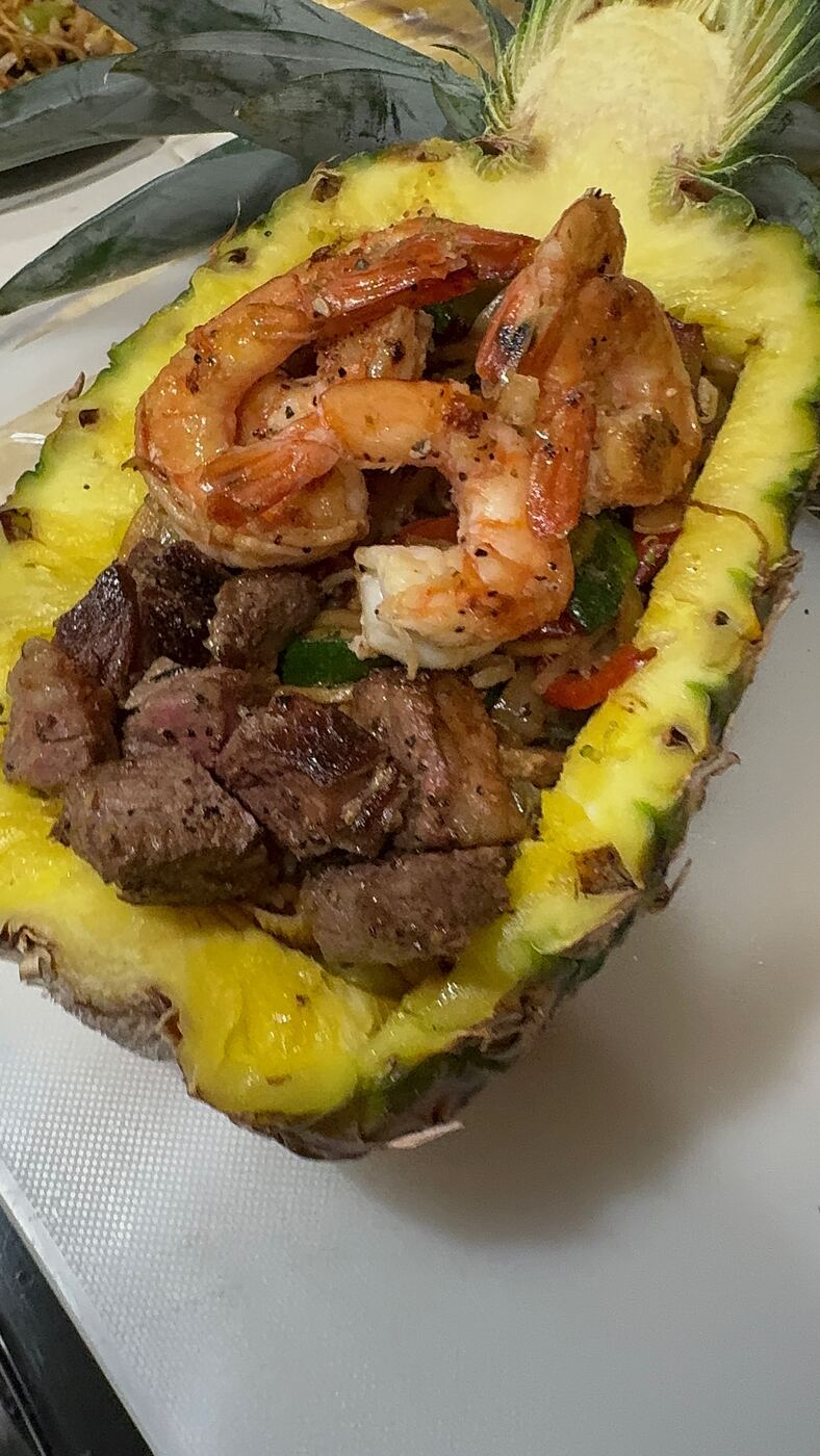 Hibachi pineapple boat filled with shrimp, steak and fried rice
